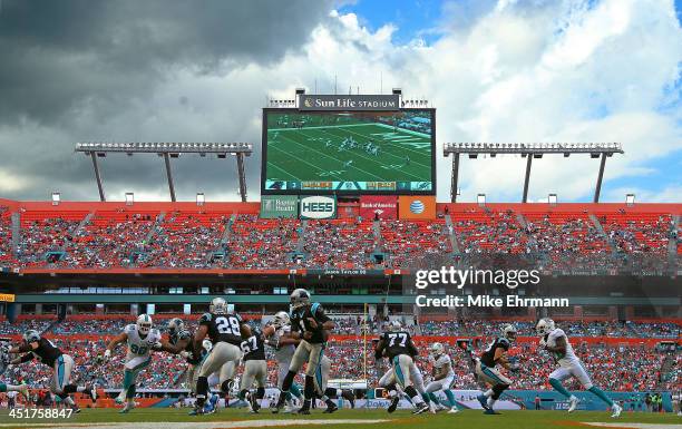 Cam Newton of the Carolina Panthers hands off to Jonathan Stewart during a game against the Miami Dolphins at Sun Life Stadium on November 24, 2013...