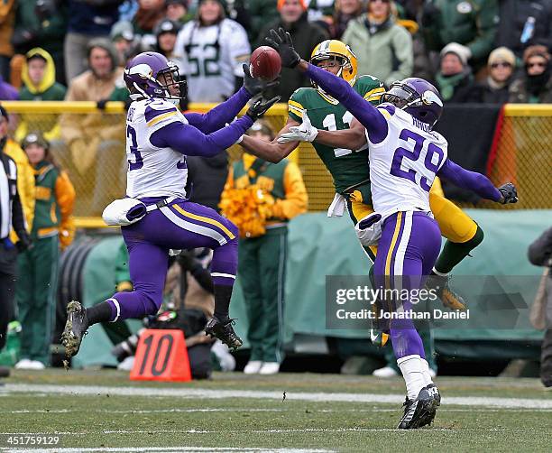 Jamarca Sanford of the Minnesota Vikings breaks up a pass intended for Jarrett Boykin of the Green Bay Packers as Xavier Rhodes also defends at...