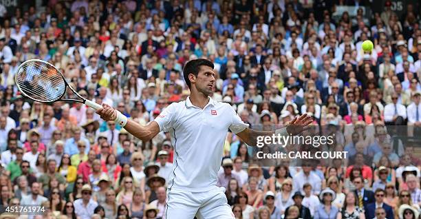 Serbia's Novak Djokovic returns the ball to Switzerland's Roger Federer during their men's singles final match on day thirteen of the 2014 Wimbledon...