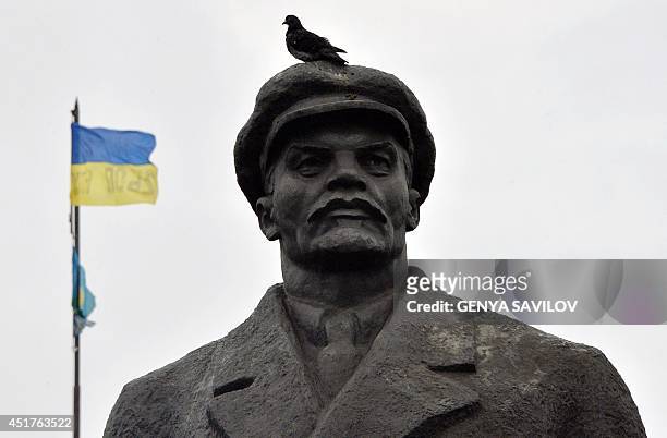 The Ukrainian flag flies on top of the city hall of the eastern Ukrainian city of Slavyansk, in the background of a Lenin's monument, on July 6,...