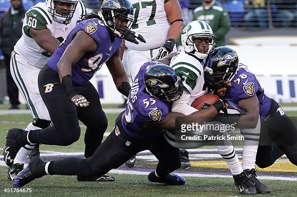 Quarterback Geno Smith of the New York Jets is sacked by outside linebacker Terrell Suggs and Elvis Dumervil of the Baltimore Ravens in the fourth...