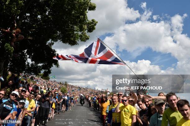 Supporters are pictured along the road during the 201 km second stage of the 101th edition of the Tour de France cycling race on July 6, 2014 between...