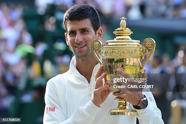 Serbia's Novak Djokovic holds the winner's trophy after beating Switzerland's Roger Federer in the men's singles final match during the presentation...