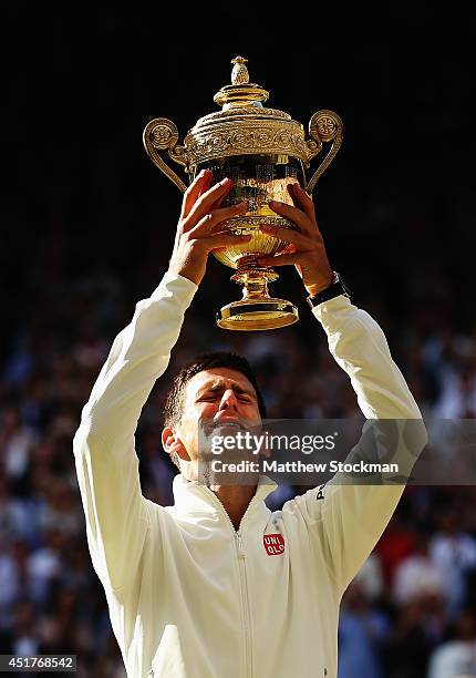 Novak Djokovic of Serbia poses with the Gentlemen's Singles Trophy following his victory in the Gentlemen's Singles Final match against Roger Federer...