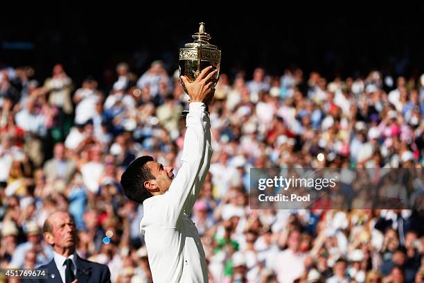 Novak Djokovic of Serbia poses with the Gentlemen's Singles Trophy following his victory in the Gentlemen's Singles Final match against Roger Federer...
