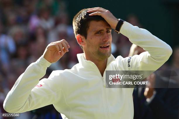 Serbia's Novak Djokovic cries as he is called to be presented with the winner's trophy after beating Switzerland's Roger Federer in the men's singles...