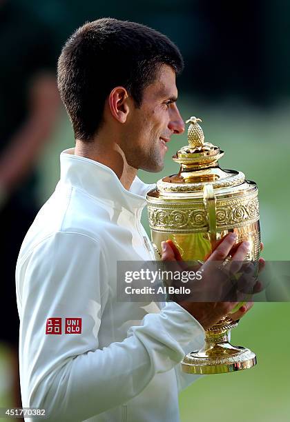 Novak Djokovic of Serbia poses with the Gentlemen's Singles Trophy following his victory in the Gentlemen's Singles Final match against Roger Federer...