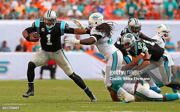 Cam Newton of the Carolina Panthers scrambles during a game against the Miami Dolphins at Sun Life Stadium on November 24, 2013 in Miami Gardens,...
