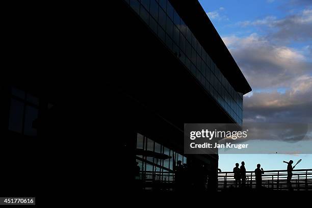 Novak Djokovic of Serbia hits signed tennis balls to the fans below from a walkway outside centre court after winning the Gentlemen's Singles Final...