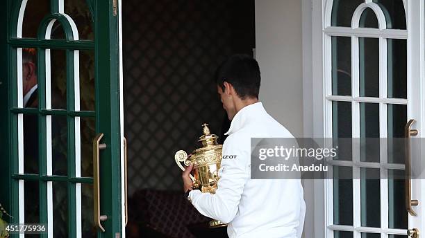 Novak Djokovic of Serbia poses with the Gentlemen's Singles Trophy after defeating his opponent Roger Federer 3-2 in the Gentlemen's Singles Final...