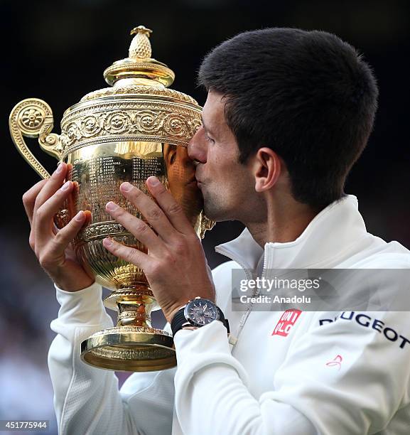 Novak Djokovic of Serbia poses with the Gentlemen's Singles Trophy after defeating his opponent Roger Federer 3-2 in the Gentlemen's Singles Final...