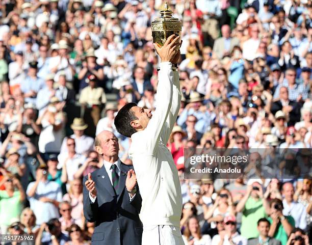 Novak Djokovic of Serbia poses with the Gentlemen's Singles Trophy after defeating his opponent Roger Federer 3-2 in the Gentlemen's Singles Final...