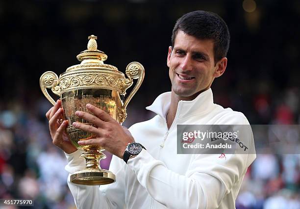 Novak Djokovic of Serbia poses with the Gentlemen's Singles Trophy after defeating his opponent Roger Federer 3-2 in the Gentlemen's Singles Final...