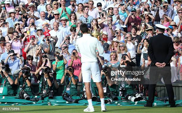 Novak Djokovic of Serbia poses with the Gentlemen's Singles Trophy after defeating his opponent Roger Federer 3-2 in the Gentlemen's Singles Final...