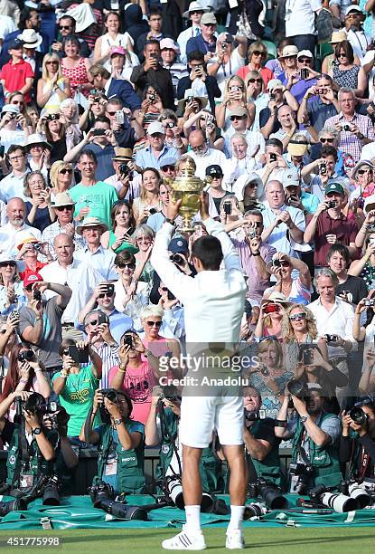 Novak Djokovic of Serbia poses with the Gentlemen's Singles Trophy after defeating his opponent Roger Federer 3-2 in the Gentlemen's Singles Final...