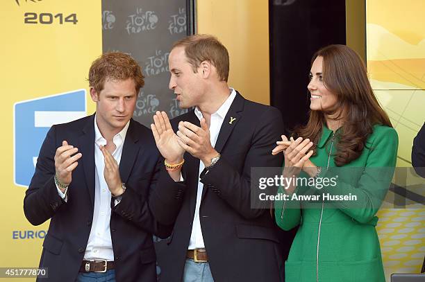 Prince Harry, Prince William, Duke of Cambridge and Catherine, Duchess of Cambridge clap as they stand on the podium at the end of of Stage 1 of the...