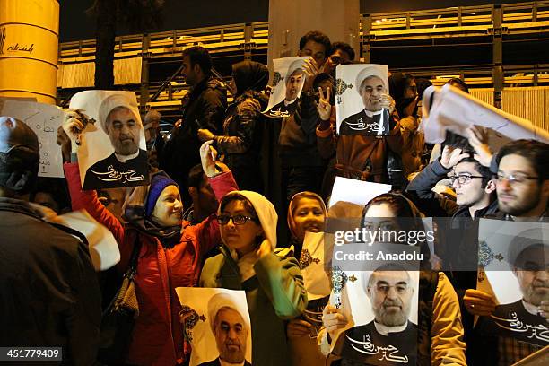 Iranians hold portraits of President Hassan Rouhani at Mehrabad Airport in Tehran on November 24, 2013 during the arrival of Foreign Minister...