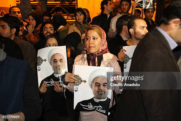 Iranians hold portraits of President Hassan Rouhani at Mehrabad Airport in Tehran on November 24, 2013 during the arrival of Foreign Minister...