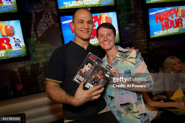Mixed martial artist Junior Dos Santos signs an autograph for a fan at the UFC Brazilian party during UFC International Fight Week inside the...