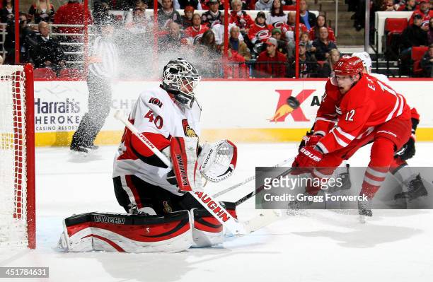 Robin Lehner of the Ottawa Senators eyes a shot as Eric Staal of the Carolina Hurricanes skates hard to the net during their NHL game at PNC Arena on...