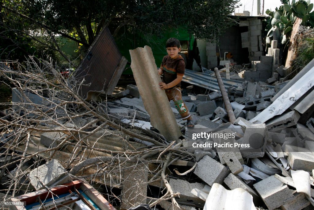 A Palestinian child stands amidst the rubble of a destroyed...