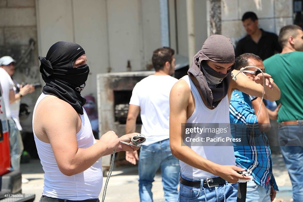 Two youths wind slingshots around their hands, ready to...