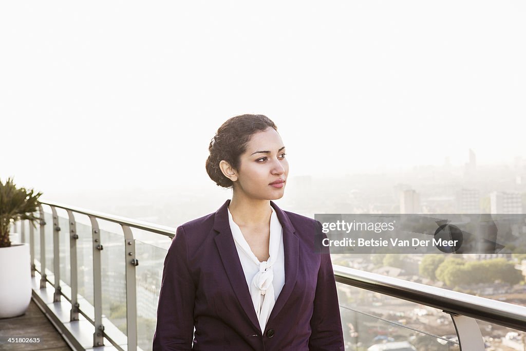 Business woman overlooking cityscape.