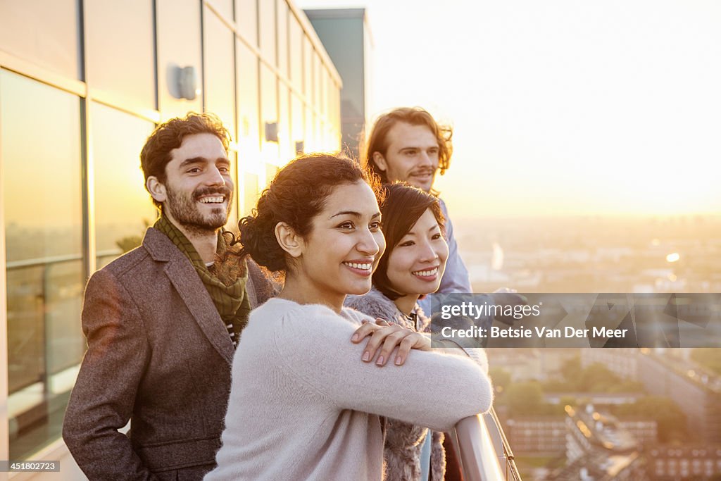 Group of friends overlooking city at sunset.