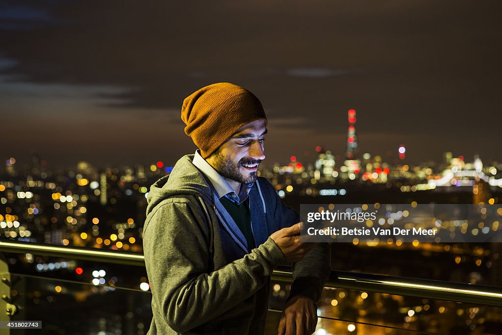 Man looking at mobile phone at night.