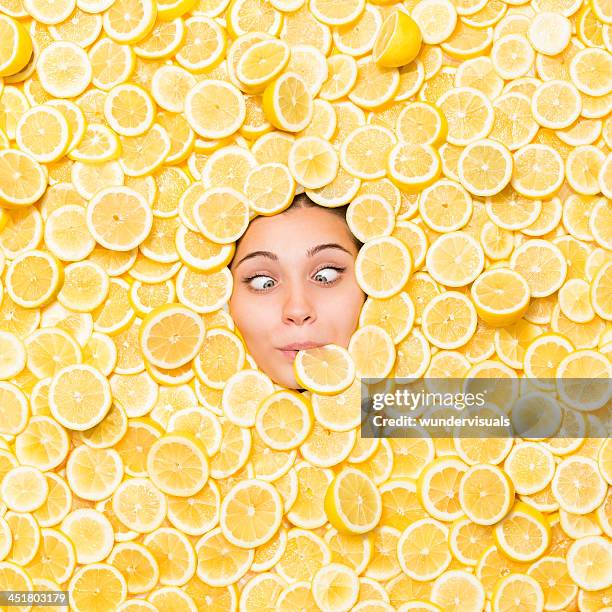 cross-eyed woman surrounded with lemon slice - zuur stockfoto's en -beelden