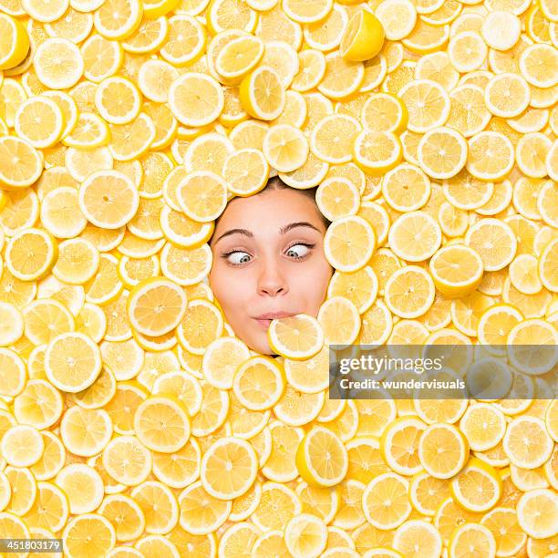 cross-eyed woman surrounded with lemon slice - lemon fruit stock pictures, royalty-free photos & images