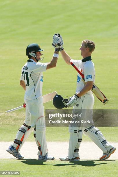 Ed Cowan of the Tigers congratulates teammate Jordan Silk after he reached 100 runs during day four of the Sheffield Shield match between the South...