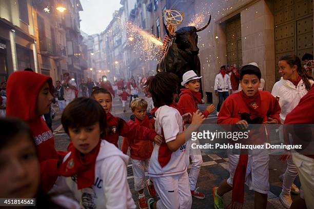 Children run away from the Toro del Fuego during the second day of the San Fermin Running Of The Bulls festival on July 7, 2014 in Pamplona, Spain....