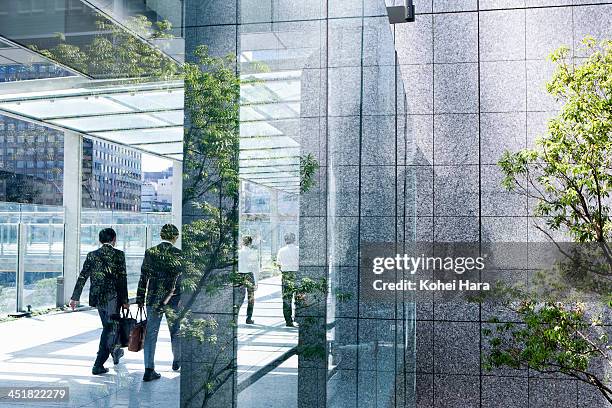 business men in office building - green glass business stock-fotos und bilder