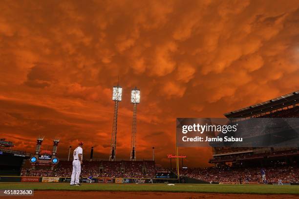 Storm clouds blanket the sky over Great American Ball Park as Starlin Castro of the Chicago Cubs fields a ground ball in the fifth inning against the...