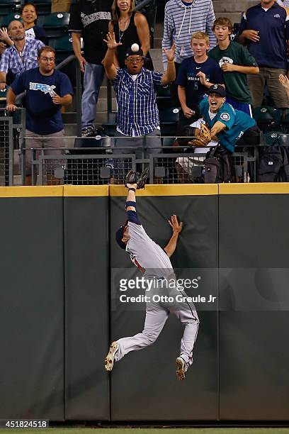 Center fielder Sam Fuld of the Minnesota Twins slams into the wall attempting to catch a home run off the bat of Michael Saunders of the Seattle...
