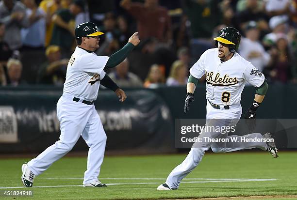 Jed Lowrie of the Oakland Athletics is waved home by third base coach Mike Gallego against the San Francisco Giants in the bottom of the sixth inning...