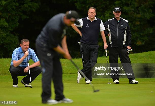 Alan Read , of west Lothian Golf Club watches his playing partner Darren Bragg of north London Golf Academy Ltd putting on the 13th green during the...