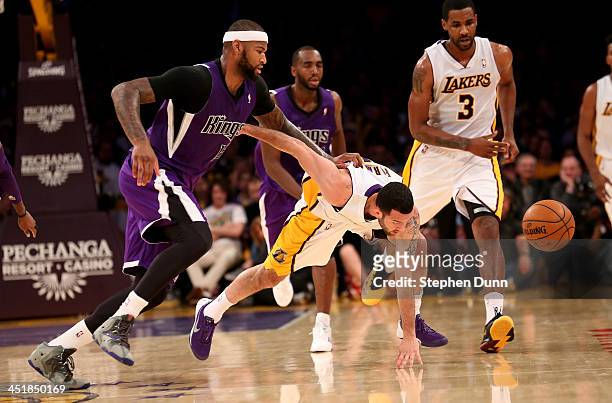 Jordan Farmar of the Los Angeles Lakers and DeMarcus Cousins of the Sacramento Kings go for a loose ball at Staples Center on November 24, 2013 in...