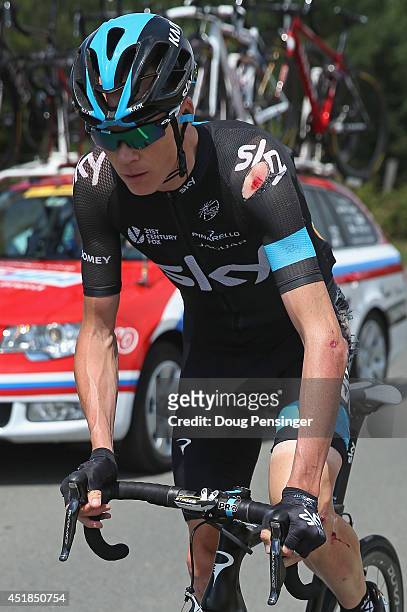 Chris Froome of Great Britain and Team Sky chases back to the peloton after being involved in a crash just afte the start of stage four of the 2014...