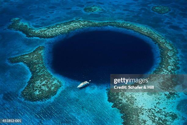 belize, lighthouse reef, boat moored at blue hole, aerial view - belize stock-fotos und bilder