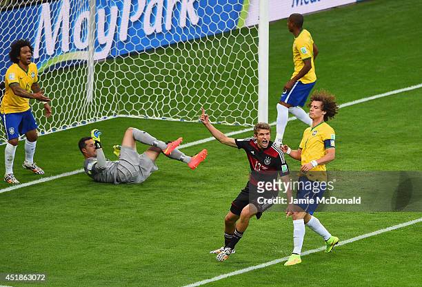 Thomas Mueller of Germany celebrates scoring his team's first goal past Julio Cesar of Brazil during the 2014 FIFA World Cup Brazil Semi Final match...
