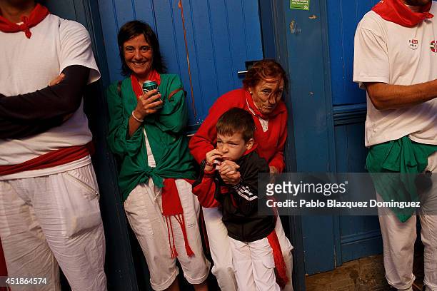 Revellers react as the Toro del Fuego passes by during the third day of the San Fermin Running Of The Bulls festival on July 8, 2014 in Pamplona,...
