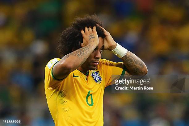 Marcelo of Brazil reacts after allowing a goal during the 2014 FIFA World Cup Brazil Semi Final match between Brazil and Germany at Estadio Mineirao...