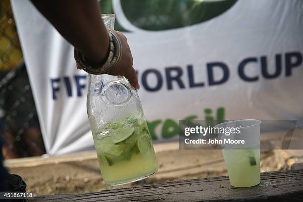 Brazilian soccer fan drinks from a pitcher of caipirinha during the semifinal World Cup game against Germany on July 8, 2014 in Port Chester, United...