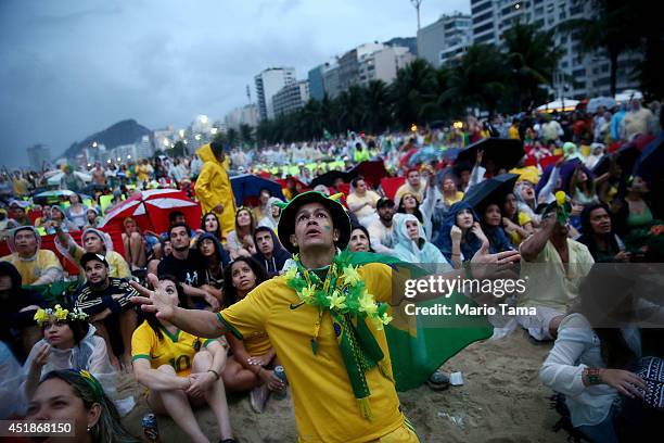 Brazil fans watch the first half on Copacabana Beach during the 2014 FIFA World Cup semi-final match between Brazil and Germany on July 8, 2014 in...