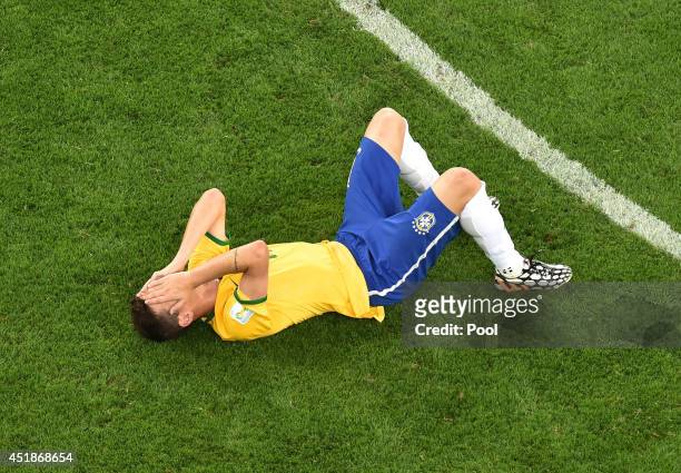 Dejected Oscar of Brazil lies on the pitch after being defeated by Germany 7-1 during the 2014 FIFA World Cup Brazil Semi Final match between Brazil...