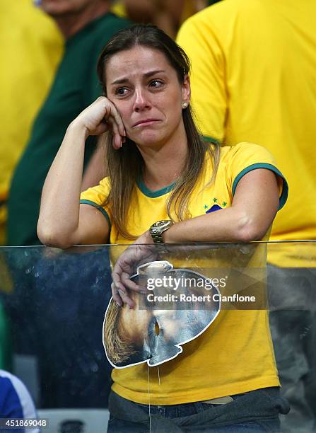 An emotional Brazil fan reacts while holding a Neymar mask after being defeated by Germany 7-1 during the 2014 FIFA World Cup Brazil Semi Final match...