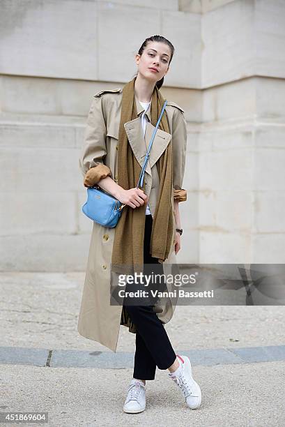 Model Larissa Hofmann poses wearing a Burberry trench, Zara pants, Adidas sneakers and Miu Miu bag after Chanel show on July 8, 2014 in Paris, France.