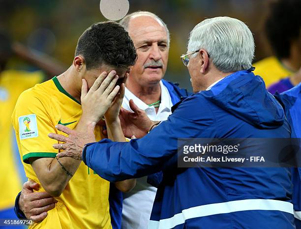 Oscar of Brazil is consoled by a team staff after the 1-7 defeat in the 2014 FIFA World Cup Brazil Semi Final match between Brazil and Germany at...